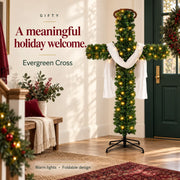 Evergreen Cross Christmas display with white drape and warm lights